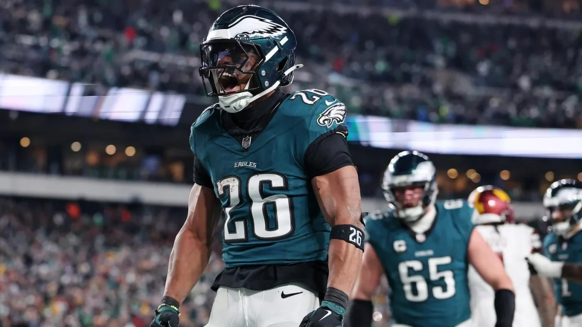 Saquon Barkley celebrating in endzone after scoring touchdown in NFC East Final against Washington Commanders.