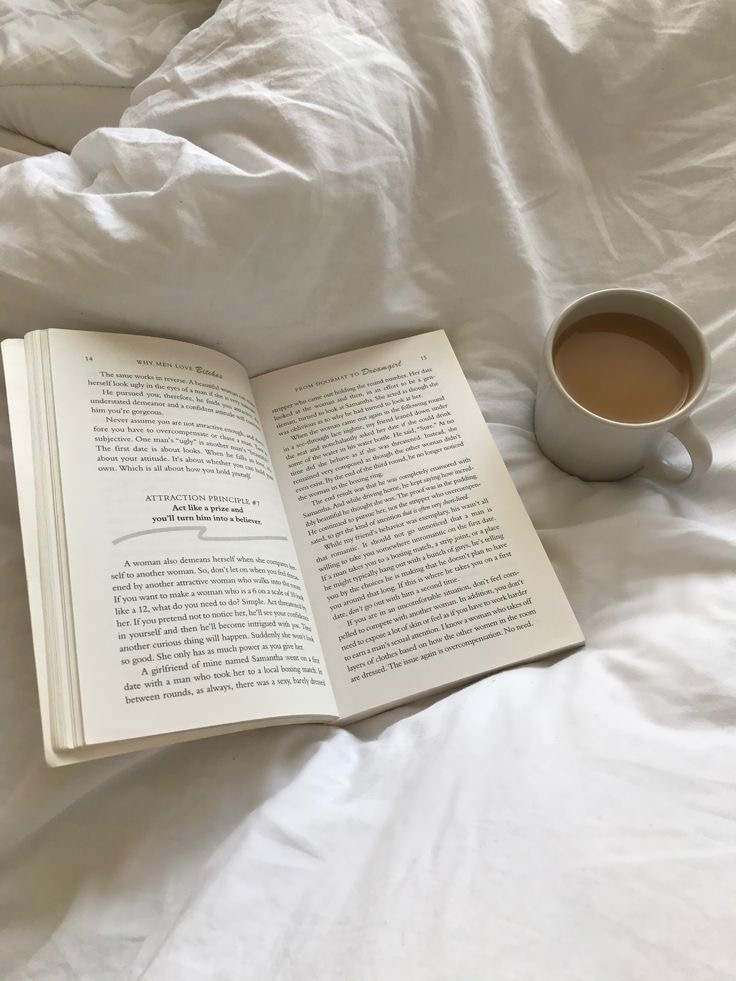 A still life of coffee and literature on white bedding illustrates the visual language of the “aesthetic” trend: calm tones, minimal clutter, and quiet intimacy.